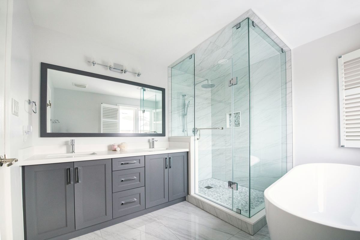 Gerenoveerde badkamer met glazen douche en lavabomeubel