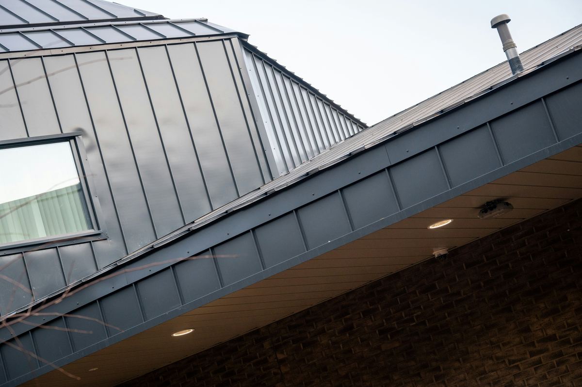 Dak en dakkapel in staande naad boven een bakstenen gevel